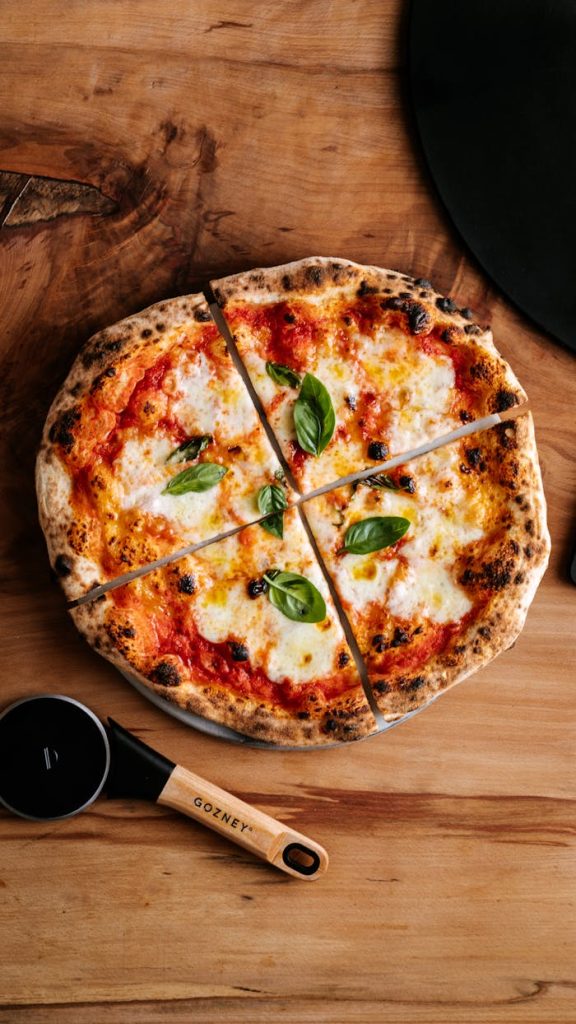 pexels-photo-20882533 A tasty Margherita pizza topped with basil, served in a London setting. Perfect for food lovers.
